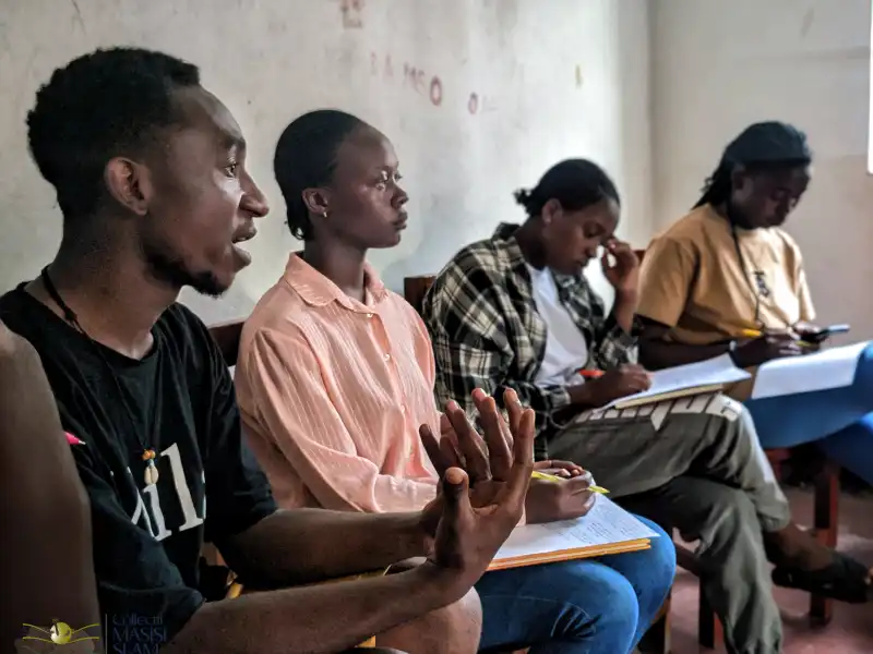 Image Du Jeudi 06 au Samedi 08 Novembre 2025, j'ai eu l'honneur de faciliter des séances de Slamotherapie organisées par le collectif Masisi Slam à Sake, une zone au noyau des conflits armés et des guerres en répétition pendant les trois décennies des guerres en RDCONGO, tristement abandonné dans sa dépression où les jeunes n'ont jamais eu un centre d'assistance psychologique ou un espace de détraumatisation, ici la psychothérapie demeure un mot nouveau, ou le psychologue un soignant inexistant. Ça a été pour moi un plaisir d'accompagner 20 Jeunes qui ont vécu les mêmes horaires que moi, des tragédies sans nom, des violences extravagantes, de la fuite de guerre au calvaire pendant une année de vie dans les camps des déplacés, jusqu'au retour dans une zone incertaine. Chaque jeune draine une histoire triste avec une réalité au-delà des principes humains, des blessures internes ignorées qui se nécrosent dans le silence de l'ignorance et le délaissement social, des monstres en gestation, des turbulents innocents nourris par le manque d'espace d'expression. J'ai été stupéfié par chaque étape de nos séances, et ému par la satisfaction des jeunes après le défoulement, entendre s'exprimer des jeunes muselés dans la solitude traumatique qui pour la première fois de leurs vies ont trouvé un climat favorable et un endroit sûr pour exprimer leurs émotions, et prendre l'engagement de poursuivre la thérapie et de renforcer la résilience. Dans une zone dépourvue des psychologues, le Slamotherapie peut faire la relève pour stabiliser, et éviter l'évolution des traumatismes chez les jeunes, qui est aussi l'une des causes de perpétuation des conflits des guerres et des violences à l'Est de la République démocratique du Congo. Je me porterai volontaire pour accompagner d'autres jeunes nécessiteux de notre assistance.
#slamothérapie 
#masisislam